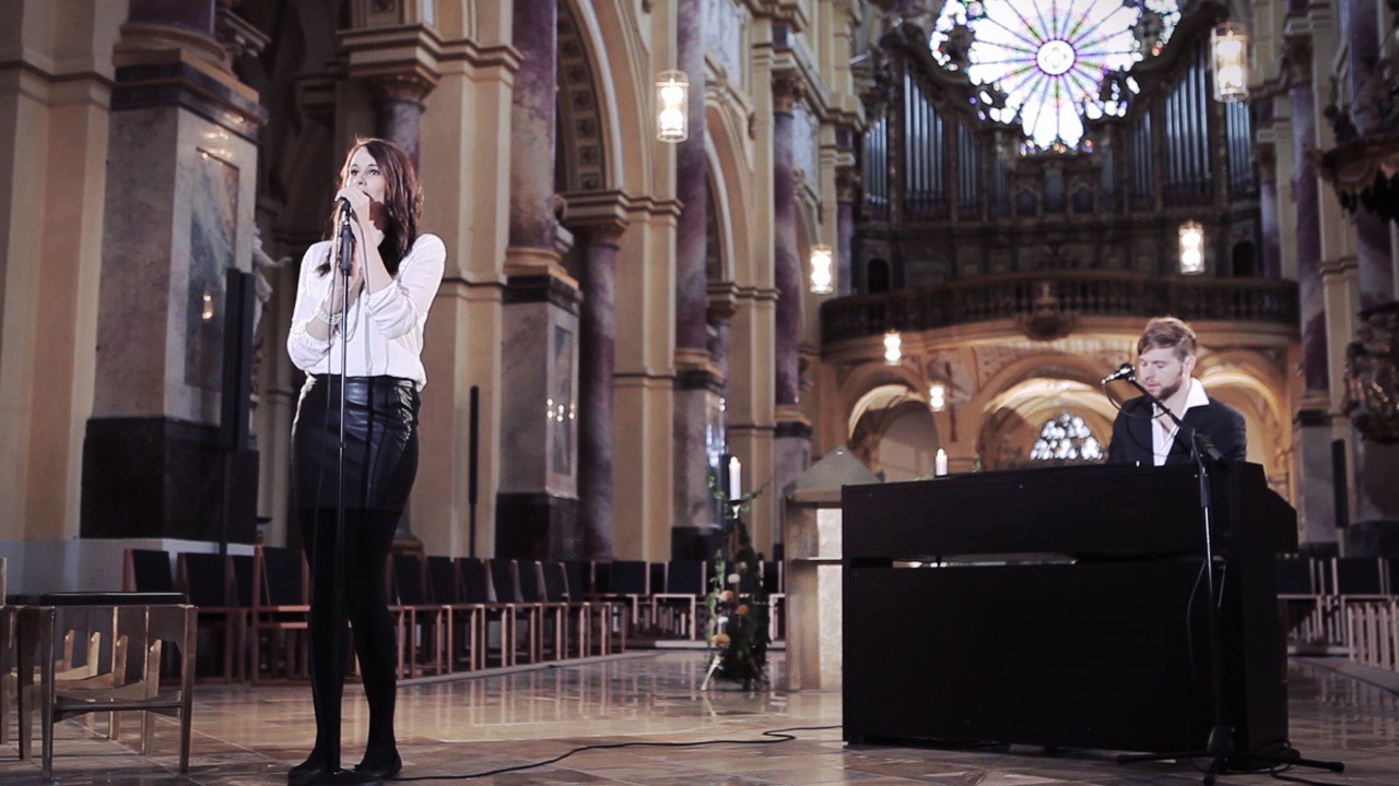 Hochzeitssängerin Svenja am Mikrofon und Hochzeitssänger Felix am Klavier vor der Orgel